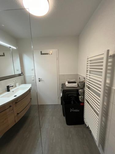 ein Bad mit einem Waschbecken und einem Spiegel in der Unterkunft Ferienwohnung MiKa in Friedrichshafen