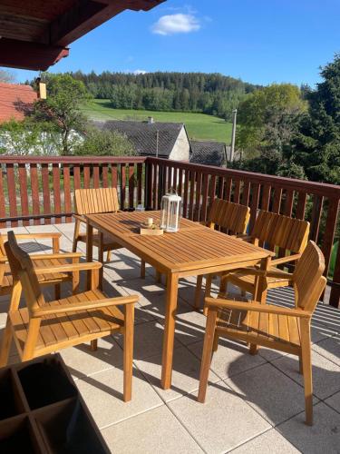 a wooden table and chairs on a deck at U farmy in Velhartice