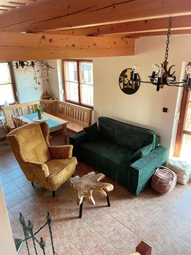 a living room with a green couch and a table at U farmy in Velhartice