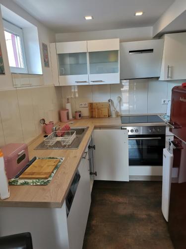 a kitchen with white cabinets and a black stove at Im Herzen des Kraichgaus 2 in Östringen
