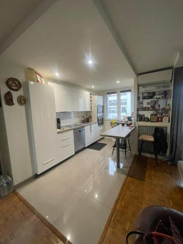 une cuisine avec un réfrigérateur blanc et une table dans l'établissement appartement 65m, à Châtillon