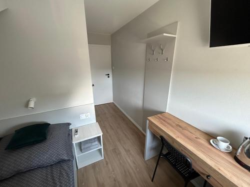 a small room with a bed and a wooden table at Milten Domaszewnica in Kolonia Domaszewnica