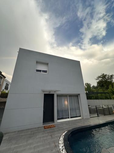 une maison blanche avec une piscine devant dans l'établissement Villa contemporaine, à Marseille