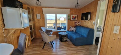 ein Wohnzimmer mit einem blauen Sofa und einem Kühlschrank in der Unterkunft Hagi 2 Road 62 nr 1 in Hagi