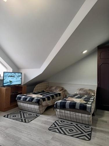 uma sala de estar com dois repousa-pés e duas camas em Family Apartments Dorobok em Lviv