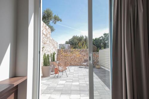 an open door to a patio with a stone wall at Alberobbè luxury rooms in Alberobello