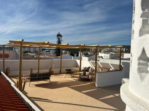 a rooftop deck with chairs and a pergola at CASA NOAVA in Loulé