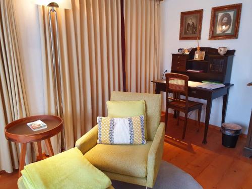 a living room with a chair and a piano at Adler Hotel in Appenzell