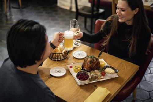 a woman and man sitting at a table with a plate of food at River Apartments in Mladá Boleslav