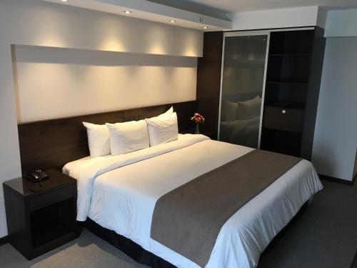 a bedroom with a large bed with white sheets at Crystal Tower in Montevideo