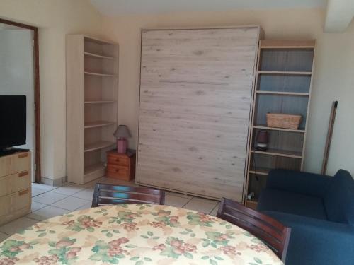 une chambre avec une table, des chaises et une porte coulissante dans l'établissement T1 47m2 + Jardin 60m2, à La Teste-de-Buch