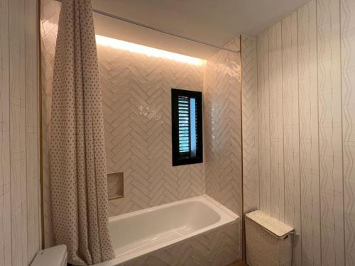 a bathroom with a bath tub with a shower curtain at Sunset Villa Arcos in Arcos de la Frontera