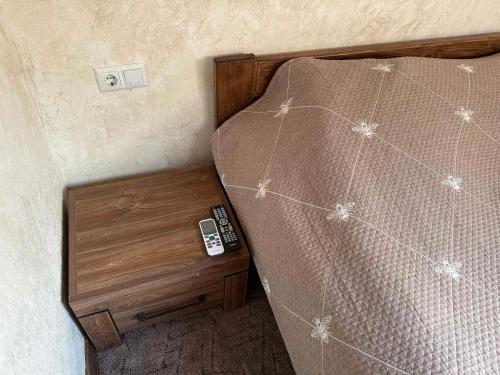 a bed with a wooden frame and a wooden night stand at Mini Hotel on Brovarskaya in Kyiv