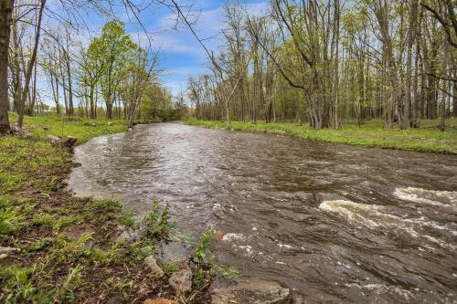 a stream of water with trees on the side at Serene Riverside Retreat home in Little Suamico