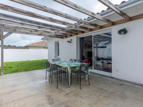 - une table et des chaises sur une terrasse avec vue sur l'eau dans l'établissement Maison climatisée à Parentis-en-Born, 3 chambres, jardin, proche centre et activités, ménage inclus - FR-1-319-554, à Parentis-en-Born