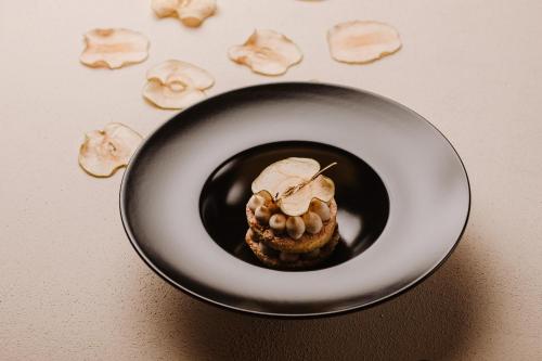 a black plate with food on a table at Locanda Solagna in Quero