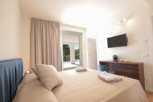 a bedroom with a bed with two towels on it at Alberobbè luxury rooms in Alberobello