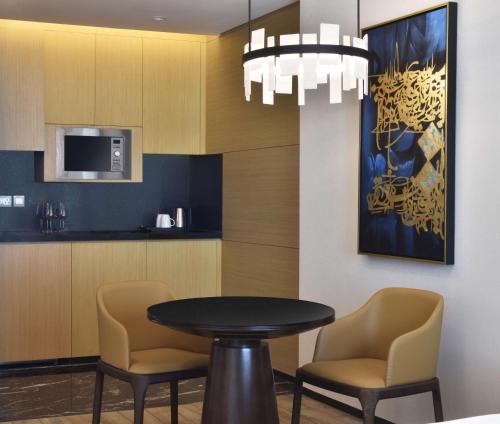 a dining room with a table and two chairs at Hilton Bahrain in Manama