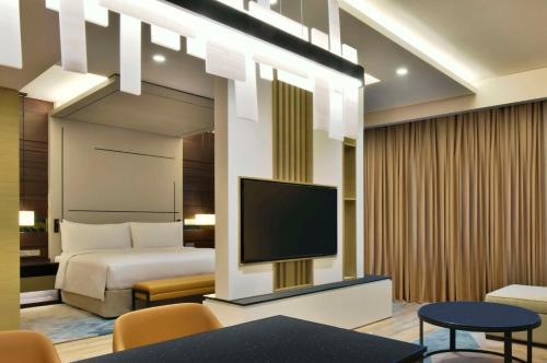 a hotel room with a bed and a flat screen tv at Hilton Bahrain in Manama