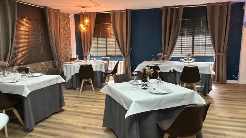 una sala da pranzo con 2 tavoli e una tovaglia bianca di Casa Ruliña a Lalín