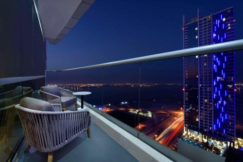a balcony with a view of a city at night at Hilton Bahrain in Manama