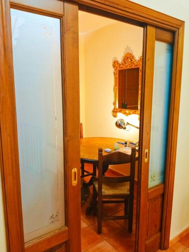 a dining room with a table and a mirror at La quercia di Massena in Lauria