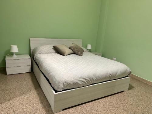 a bedroom with a bed with two night stands and two lamps at Acqua Marina apartment in Acquaviva delle Fonti