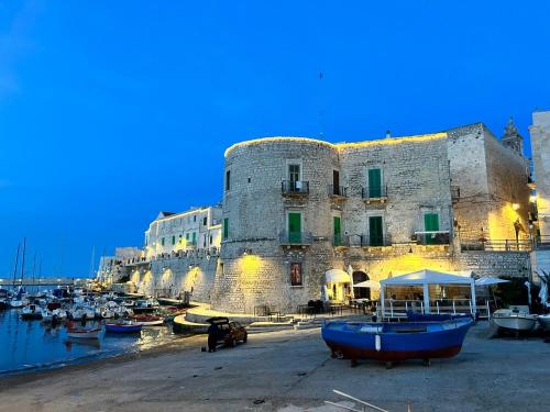 a large stone building with boats in a harbor at Acqua Marina apartment in Acquaviva delle Fonti