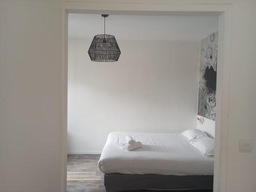 a white room with a bed and a pendant light at Arty Paris Porte de Versailles by River in Paris