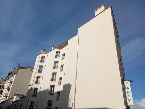 a large white building in front of a blue sky at Arty Paris Porte de Versailles by River in Paris