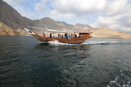 un groupe de personnes sur un bateau dans l'eau dans l'établissement Overnight Dhow - 1 Night 2 Days, à Khasab