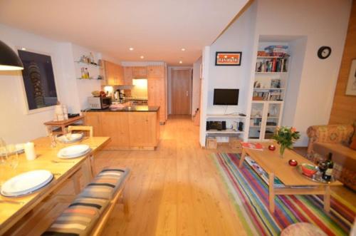 a living room with a table and a kitchen at Au Pied des Pistes C7, Grimentz - Modern 3 Bedroom Duplex, Sleeps 8 in Grimentz