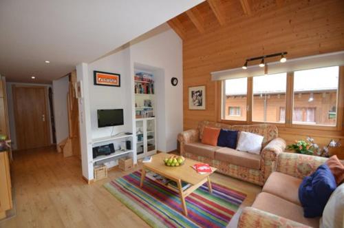 a living room with a couch and a table at Au Pied des Pistes C7, Grimentz - Modern 3 Bedroom Duplex, Sleeps 8 in Grimentz