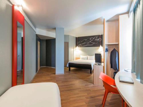 a hotel room with a bed and a desk at Ibis Sevilla in Seville