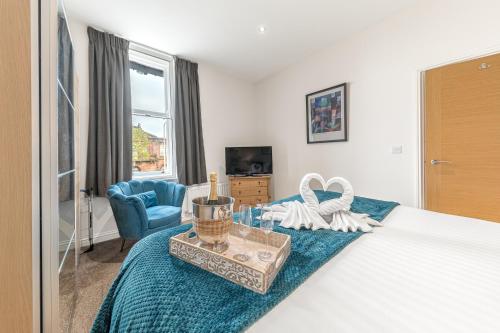 a bedroom with a bed with a blue blanket at Abbey Apartments Modern ApartHotel for Tourists & Professionals in Barrow in Furness