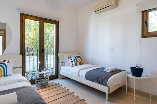 a bedroom with two beds and a balcony at Lumina 2-Bedroom Villa and Pool in Ayia Napa in Ayia Napa