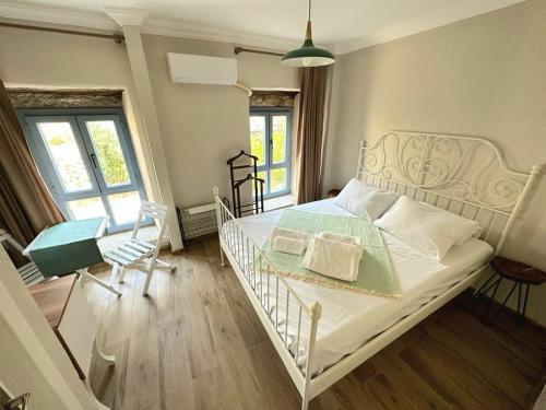 een slaapkamer met een wit bed en 2 stoelen bij Via Alaçatı Otel in Çeşme