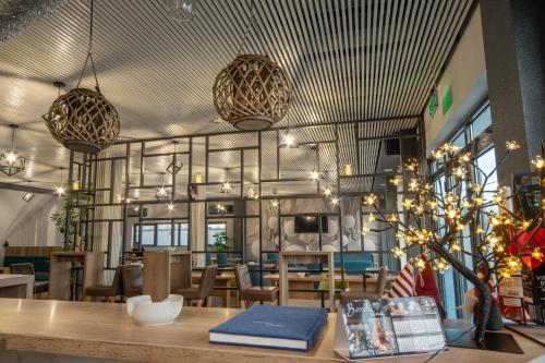 un restaurante con mesa, sillas y luces en AMD UNION Caffe & Rooms en Kruševac