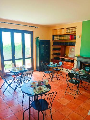 a room with tables and chairs and a fireplace at La quercia di Massena in Lauria