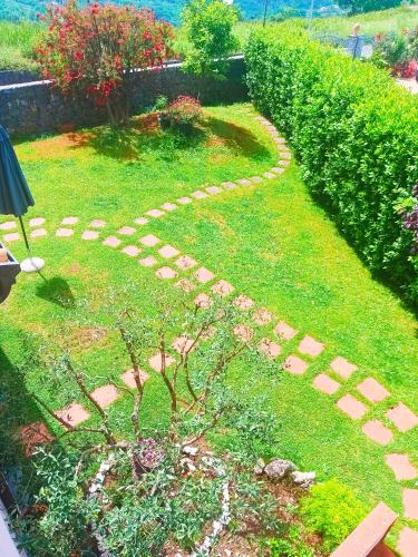 a garden with a stone path in the grass at La quercia di Massena in Lauria