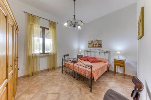 a bedroom with a bed and a table and a window at Villa Cisura Ranne - 2 chilometri dal mare con piscina privata in Diso