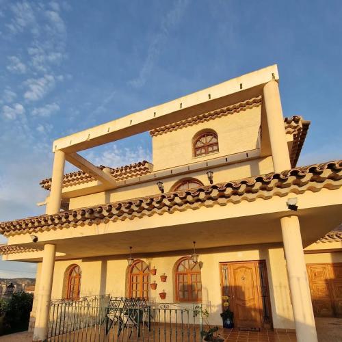 a large building with a balcony on top of it at Villa los Dulces-Piscina Privada in Letur