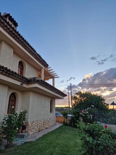 a house with a grass yard next to a building at Villa los Dulces-Piscina Privada in Letur