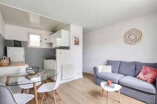un salon avec un canapé et une table en verre dans l'établissement Lumineux gite avec jardin dans une bastide, à Montpellier