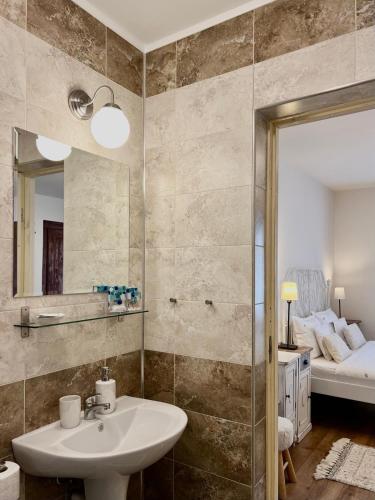 a bathroom with a sink and a mirror and a bed at Casa De Gallois in Sinaia