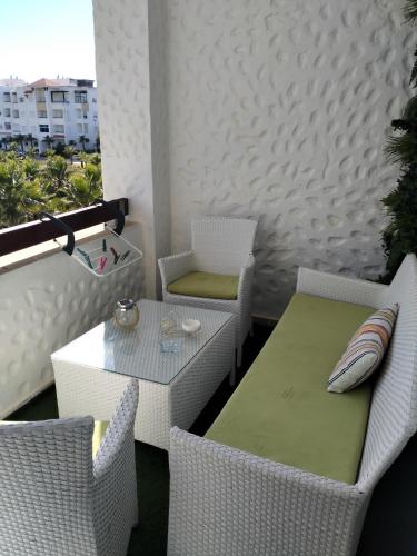 a balcony with a table and chairs on a balcony at assilah marina golf assilah in Asilah