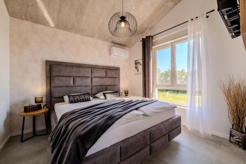 a bedroom with a large bed and a large window at Villa Sunset Grusi ZadarVillas in Briševo