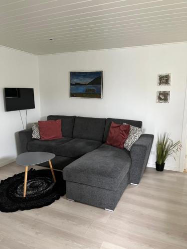 a living room with a couch and a table at Cosy groundfloor apartment in Sørvágur