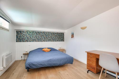 - une chambre avec un lit bleu et un bureau dans l'établissement Lumineux gite avec jardin dans une bastide, à Montpellier