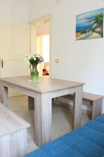 a wooden table with a vase of flowers on it at Cilento Casa Vacanza Giuvino in Castelnuovo Cilento